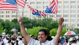 Demonstrator Jesus Sandovar waves four American flags at an immigration rally in Dallas.