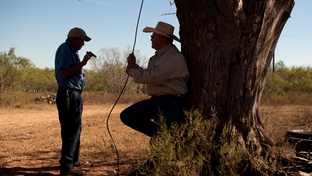 Victor Elizando and Noe Obregon rest in the shade during a visit to the farmland Obregon used to tend before the USDA's discriminatory loan practices put him out of business.