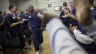 Brandon Biko Reese, who will soon be released after serving a five-year sentence, is enthusiastically welcomed to the front of the room to give a farewell speech. In an effort to "de-gangsterize" inmates, administrators encourage them to dance and cheer for their peers whenever possible.