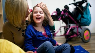 Laura Romero plays with her daughter Brooklyn, who has Cerebral Palsy, during the open house and tour of Seton's new Children's Comprehensive Care Clinic in Austin, Texas.