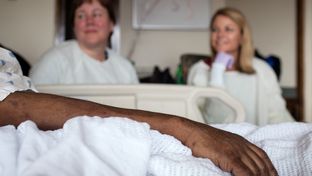 Dr. Leigh Fredholm, medical director of Seton Palliative Care, and Liz Powell, Seton’s Network Palliative Care Chaplain, visit a patient at the University Medical Center at Brackenridge in Austin.