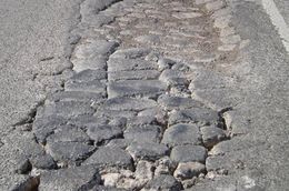 A road in the Eagle Ford Shale area in South Texas. The natural gas drilling boom is straining the region's rural roads. More than 1,000 loaded trucks are needed to bring a single well into production.