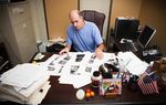 Victim Advocate for the City of Houston Andy Kahan, with crime scene photos printed off websites showing dead bodies, many unclothed, in his office at the Houston Police Department in Houston, Monday May 6, 2013.