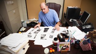 Victim Advocate for the City of Houston Andy Kahan, with crime scene photos printed off websites showing dead bodies, many unclothed, in his office at the Houston Police Department in Houston, Monday May 6, 2013.