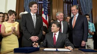 Gov. Rick Perry smiles after signing HB 5 the education reform bill before a crowd in the Governor's Reception Room on June 10, 2013. Left to right are Sens. Donna Campbell, R-New Braunfels, Dan Patrick, R-Houston, Rep. Jimmie Don Aycock, R-Killeen and Lt. Gov. David Dewhurst.