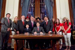 Gov. Rick Perry signs House Bill 308 which allows public school students and staff to use traditional holiday greetings and display religious symbols on school property. He was joined by bill author Rep. Dwayne Bohac R-Houston, Bahac's  son Reagan, Sen. Robert Nichols as well as several Santa's, Rabbi Zev Johnson and cheerleaders from Kountze High School - June 13, 2013.