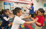 Pre-K teacher Josefina Pineda teaches her students the concept of "push" by having them join hands and push back and forth in her classroom at the Dallas Independent School District elementary school Cesar Chavez Learning Center in Dallas, Texas.