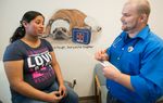 Dr. Brad Faglie, one of the family physicians being denied hospital privileges at the nearby Wise Regional Health System, examines Adriana Zuniga, a pregnant Medicaid patient at a medical clinic in Alvord.