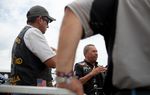 Alejandro Rojas, left, and Jorge Rojas Lopez, center, speak with other members of the Dorados De Villa motorcycle club at the Republic of Texas Biker Rally in Austin, Texas June 14th, 2013.