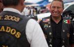 Jorge Rojas Lopez speaks with other members of the Dorados De Villa motorcycle club at the Republic of Texas Biker Rally in Austin, Texas June 14th, 2013.