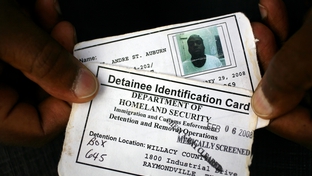 A detainee with mental health problems shows his ID card, which says he's been medically screened. 