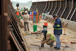 Construction workers for the Mexican contracting company Coconao work on a segment of the new rail bridge that stands over the Rio Grande.