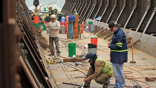 Construction workers for the Mexican contracting company Coconao work on a segment of the new rail bridge that stands over the Rio Grande.