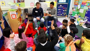 National Honor students Zach Calkins and Aaron Gonzales, seniors at Brandeis High School, read to kindergarten students in a crowded classroom at Wanke Elementary School in San Antonio on March 9, 2012.