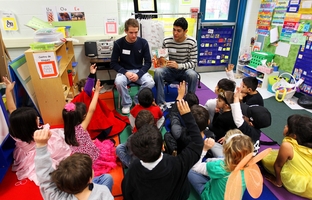National Honor students Zach Calkins and Aaron Gonzales, seniors at Brandeis High School, read to kindergarten students in a crowded classroom at Wanke Elementary School in San Antonio on March 9, 2012.