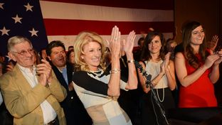 Wendy Davis, flanked by her father, Jerry Russell at left and her two daughters, at right, applauds her supporters during her victory speech at the Fort Worth Hilton on November 6, 2012.
