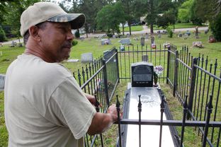 Reverend Rodney Norsworthy, a minister at Mount Olive Missionary Baptist Church, shows the grave of James Byrd, at a cemetery in Jasper, TX on June 15 2012.