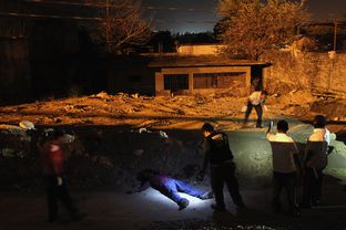 A forensics team inspects the body of a man killed in a suspected drug-related execution along the path where he was shot on March 1, 2012 in Acapulco, Mexico.