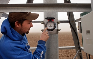 Kyle DuBois of Massey Irrigation examines a recently-installed well water meter in Lubbock, TX, on Mar. 8, 2012.