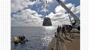 A crane lifts SpaceX's Dragon spacecraft on to a barge after the vehicle twice orbited the Earth in December of 2010.