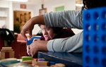 Resident Bea Garza ("B.B.") is assisted by Trina Howard, an employee at the state school.