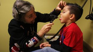 Dr. Sarah Helfand exams a patient during his checkup at Kessler Pediatrics in Dallas.