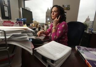 Genevieve Davis, director of payment advocacy for the Texas Medical Association working the computer and her phone at her desk in Austin, Texas February 20, 2012.