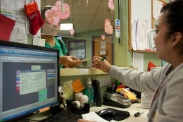 A patient at The People's Community Clinic pays her bill as the cashier’s desk.  The Community Health Assistance Program, a program that helps Texans get access to insurance, will run out of federal grant money in a few weeks.