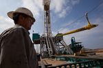 A worker waits to load a piece of pipe, or casing, that will be lowered into the well at a Chesapeake Energy drill site in Dimmit County, Texas in the Eagle Ford Shale.