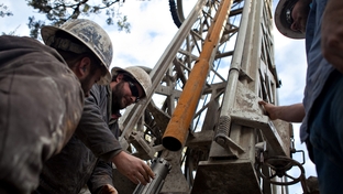 Workers with Bee Cave Drilling install a jackhammer bit on the drilling rig while putting in a water well on a private lot in Spicewood, Texas on February 6, 2012.