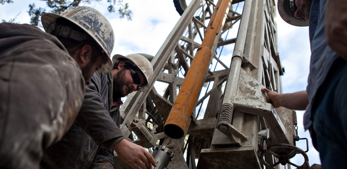 Workers with Bee Cave Drilling install a jackhammer bit on the drilling rig while putting in a water well on a private lot in Spicewood, Texas on February 6, 2012.