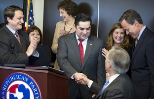 State Representative J.M. Lozano (center) shakes hands with Attorney General Greg Abbott as he announces that he's switching to the Republican Party during a press conference Thursday, March 18, 2012.