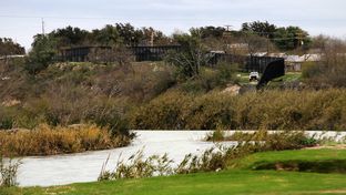 The Rio Grande and a towering border fence separate Eagle Pass, Texas from Piedras Negras, Mexico, Saturday, February 4, 2012.