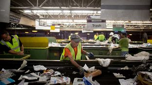 A Greenstar Recycling Center  employee removes plastic bags from a sort line in Garland, Texas, September 13, 2012.