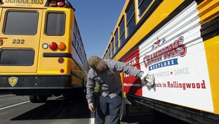 Eanes ISD school bus mechanic Chase Roberts washes the dirt off the advertising on Eanes ISD school buses in Westlake, Texas Tuesday February 14, 2012.