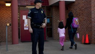 Austin Police Officer Cory Ehrler monitors the entrance to Ridgetop Elementary School after classes start on the Monday following the Sandy Hook Elementary School shooting. As the 83rd legislative session approaches, Texas lawmakers are considering making firearms more available to teachers and other school personnel.