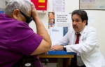 Dr. Javier Saenz with a patient, Elena Chavez, 73. Chavez is part of the 50 percent of patients Saenz sees who draw from both Medicare and Medicaid.