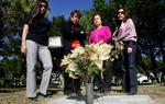 Juanita Guerra, second from right, stands at the grave of her husband in the San Benito Mont Meta Cemetery with her three daughters on Sunday Dec. 12, 2010. Ms. Guerra is suing Service Corporation International, the largest funeral services provider in North America, for moving her husband's remains without her permission. 