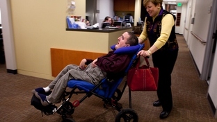 Ann Ligums pushes her profoundly disabled son Benjamin, 26, into the Baylor Transition Medicine Clinic in Houston. 