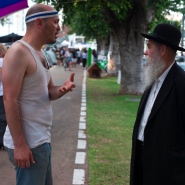 Tent protests alongside a young activist and older, religiously clad man