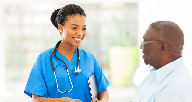 A nurse shaking hands with an older male patient.