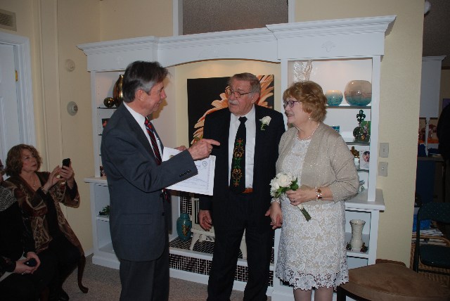 Rev. George Patterson instructs the bride and groom concerning the marriage certificate.