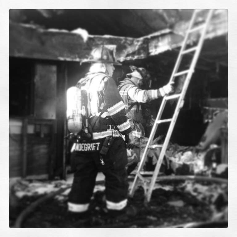 Josh Vandegrift, left, a Cocoa firefighter and paramedic, puts out hotspots after a trailer fire. The photo was taken before Vandegrift was diagnosed with PTSD after responding to an accident where his brother died in 2016. (Photo by Brevard County Fire Chief Schollmeyer)