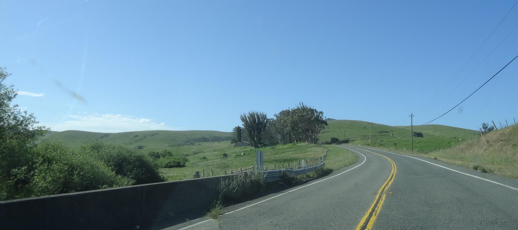 The road opens up some as you go through the hills. Really, the soil is rocky and not so fertile, so it is an area for pastures of sheep and cattle. It is a lonely place with scattered farmhouses.