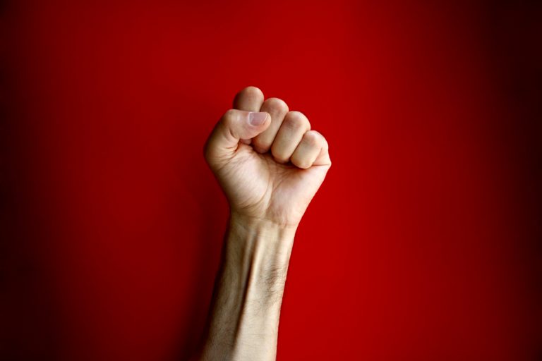 Clenched Fist on Red Background CARP