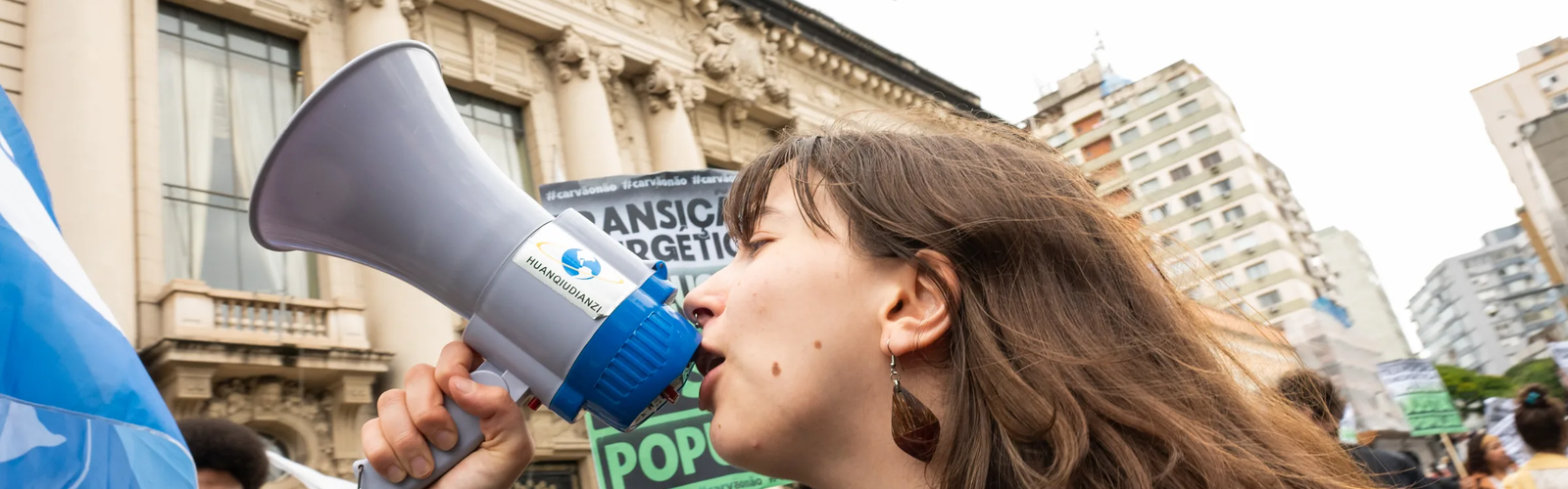 Jovem ativista fala ao megafone em ato pela transição energética justa em Porto Alegre