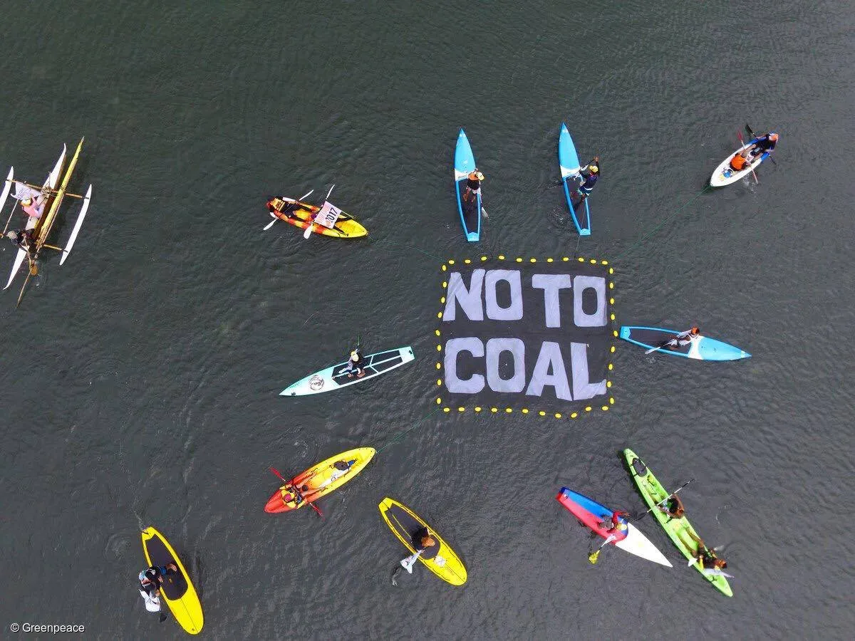 Paddlers unfurl a floating banner near the site of the proposed Ludo coal-fired power station. Photo: Greenpeace Philippines