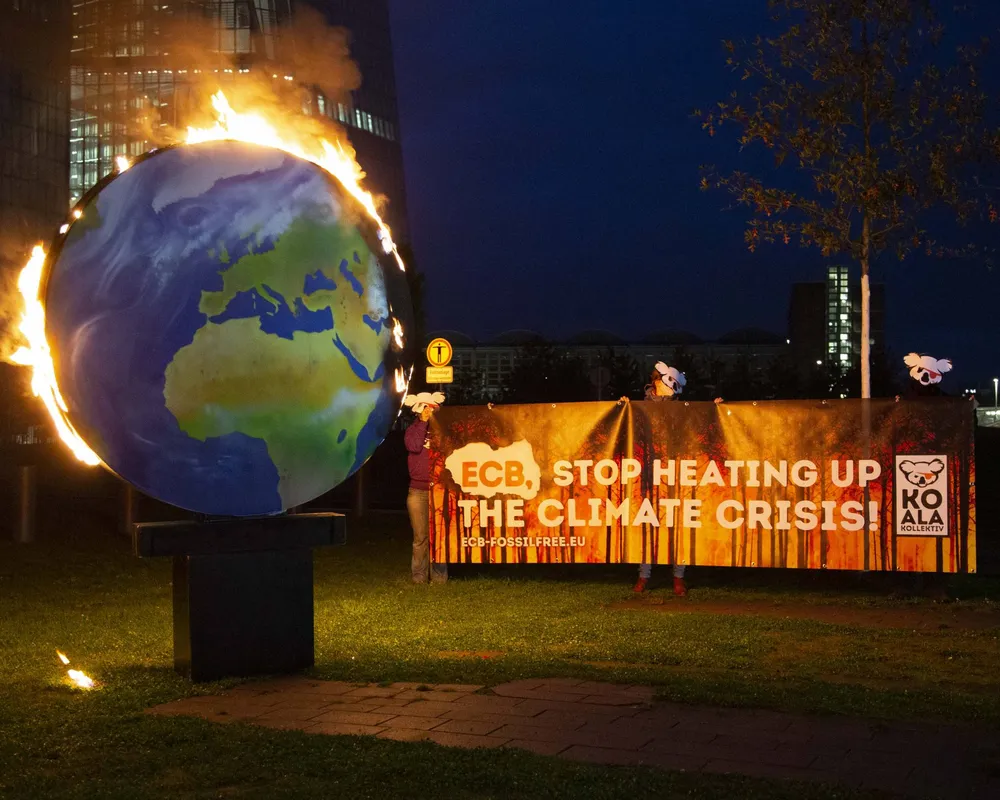 A model planet Earth was set on fire in front of the ECB headquarters in Frankfurt.
