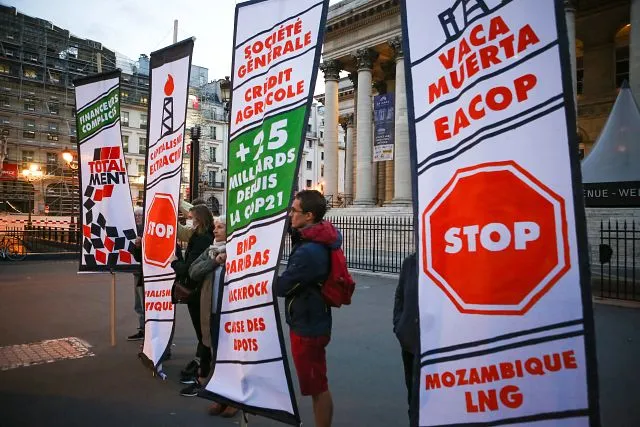 French grassroots groups hold a Total Ment demonstration to draw attention to the oil giant's responsibility in driving the climate crisis and for lying to their shareholders, Palais Brongniart, France. Photo: Jean Nicholas Guillo
