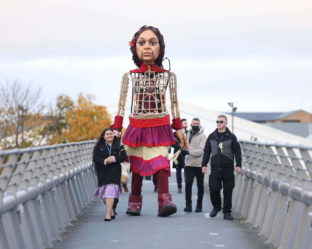 Little Amal and Pacific Climate Warrior Brianna Fruean approach COP26 in Glasgow.
